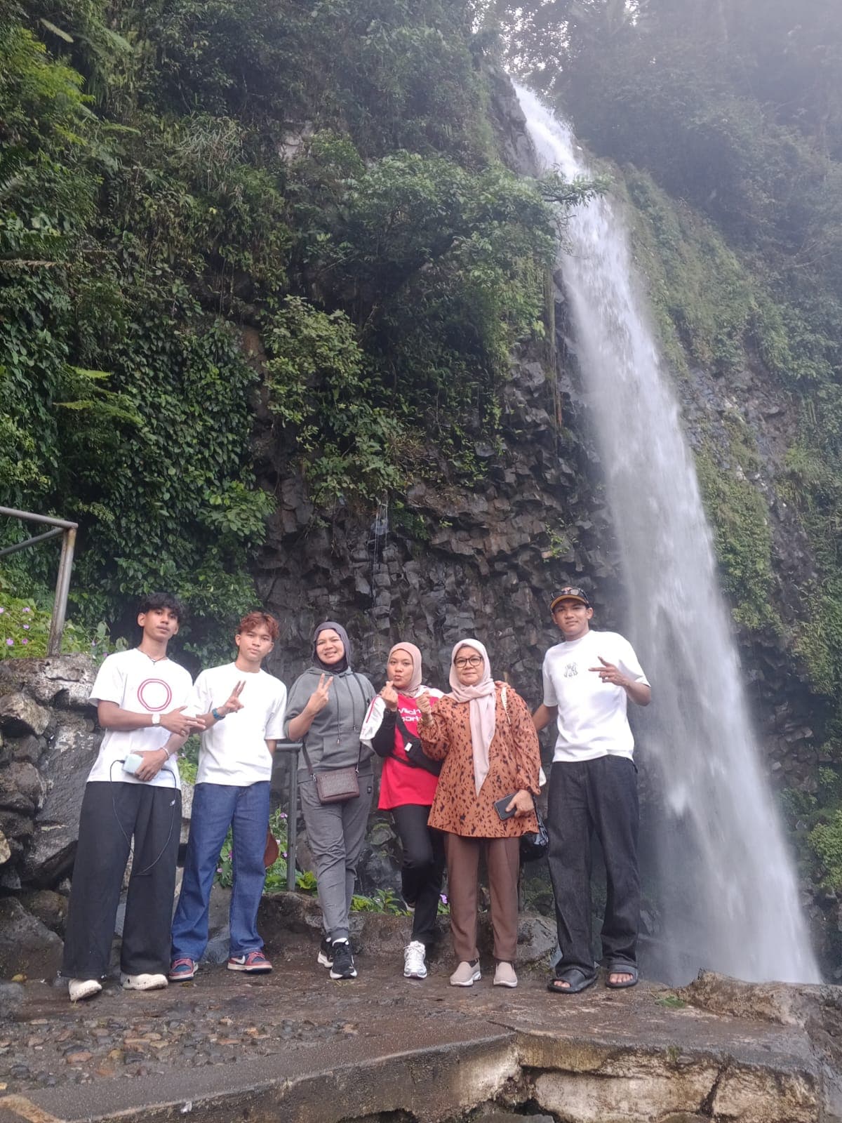 Rombongan wisata berfoto di depan Air Terjun Lembah Anai